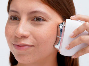 woman using AuraLift Guasha on cheekbones